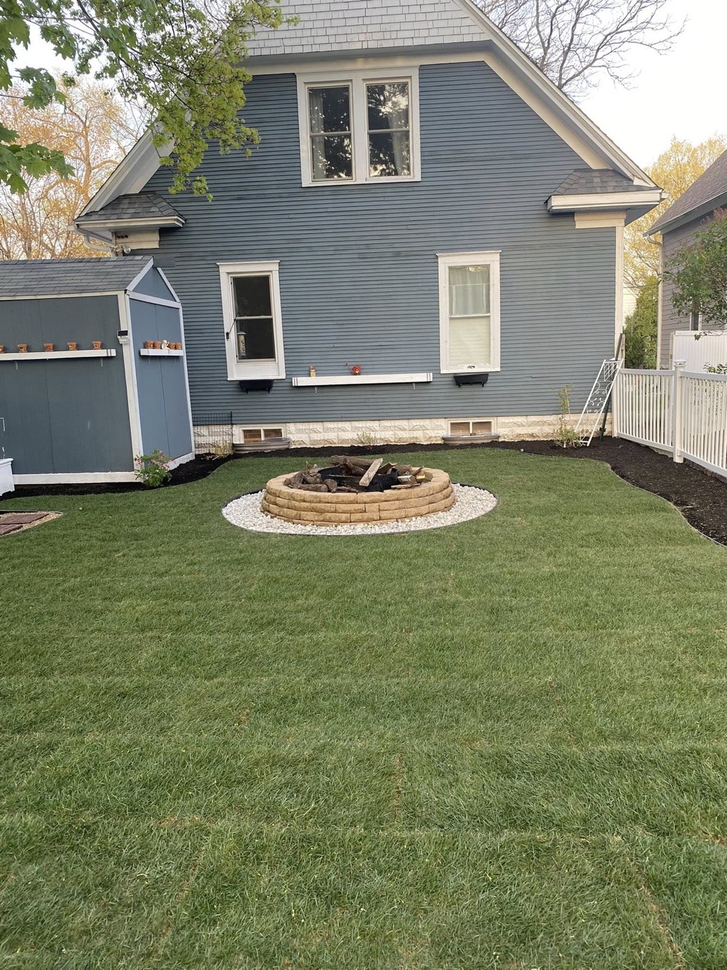 Finished lawn and fire pit area completed by Hernandez Landscape in DeKalb